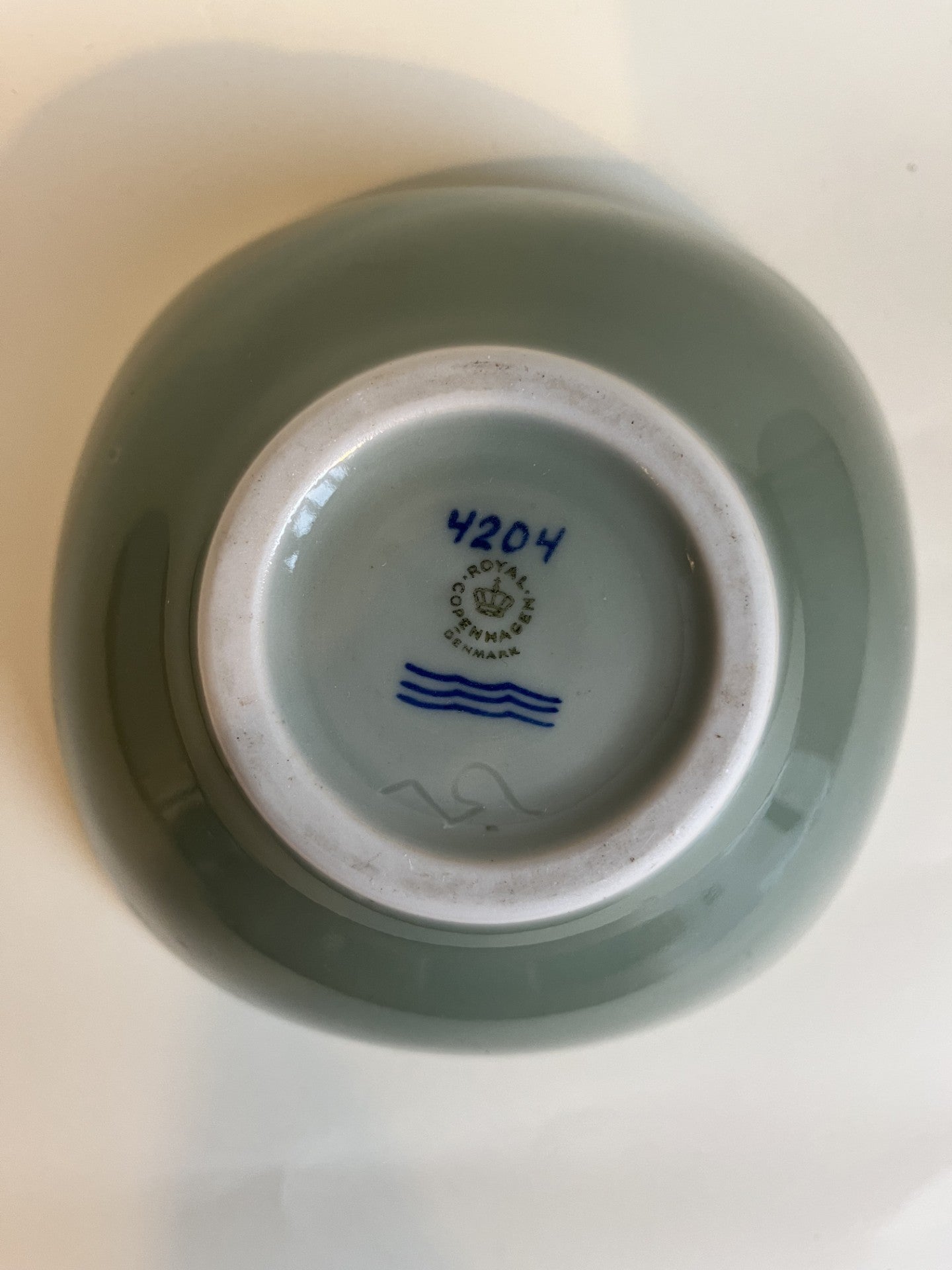 Royal Copenhagen bowl by Nils Thorsson with celadon glaze and fish at the bottom - no. 1010